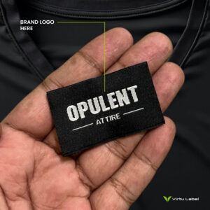 a hand holding a black clothing label for your brand