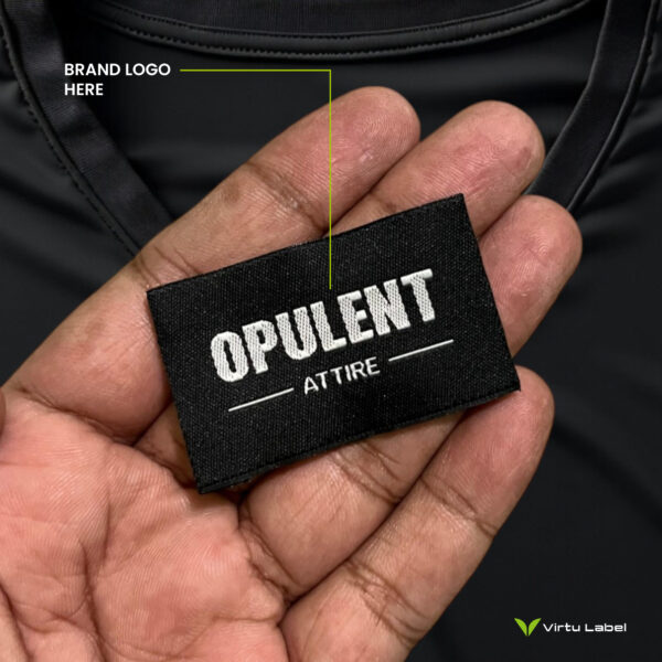 a hand holding a black clothing label for your brand