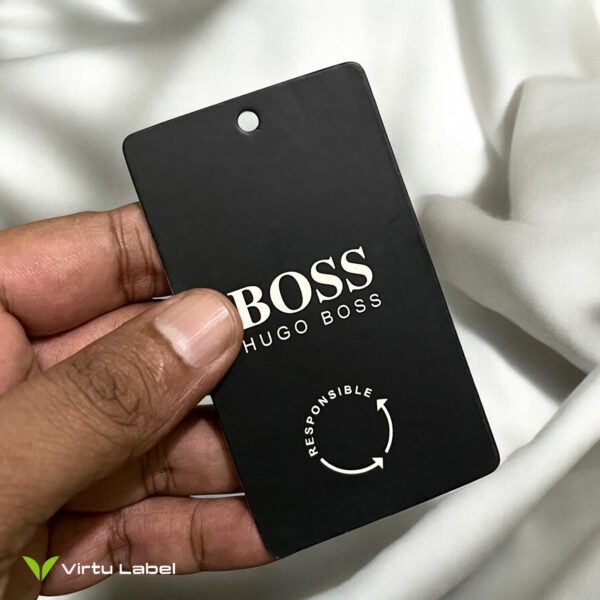 a hand holding a black clothing hang tag card