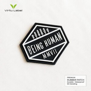 Custom hexagonal rubber patch with raised white tree design and Being Human text