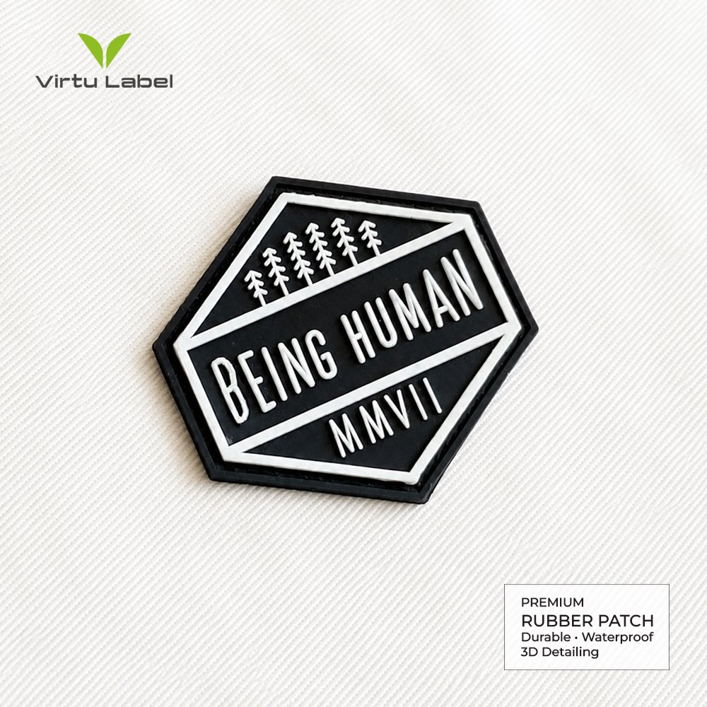 Custom hexagonal rubber patch with raised white tree design and Being Human text